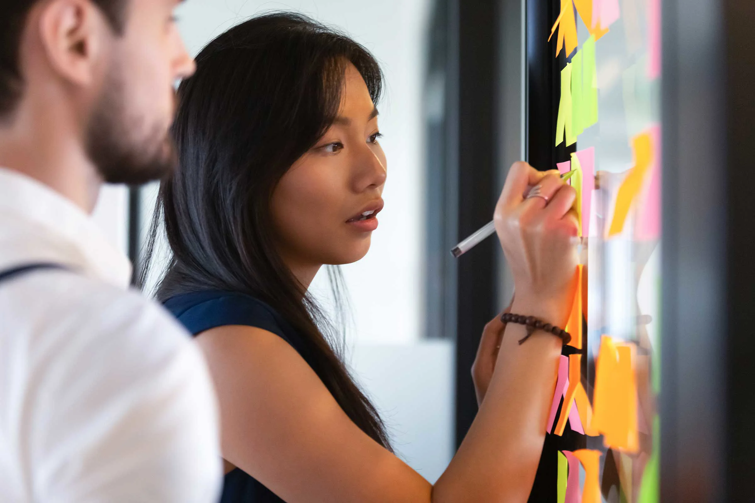 Man and woman writing on post it notes
