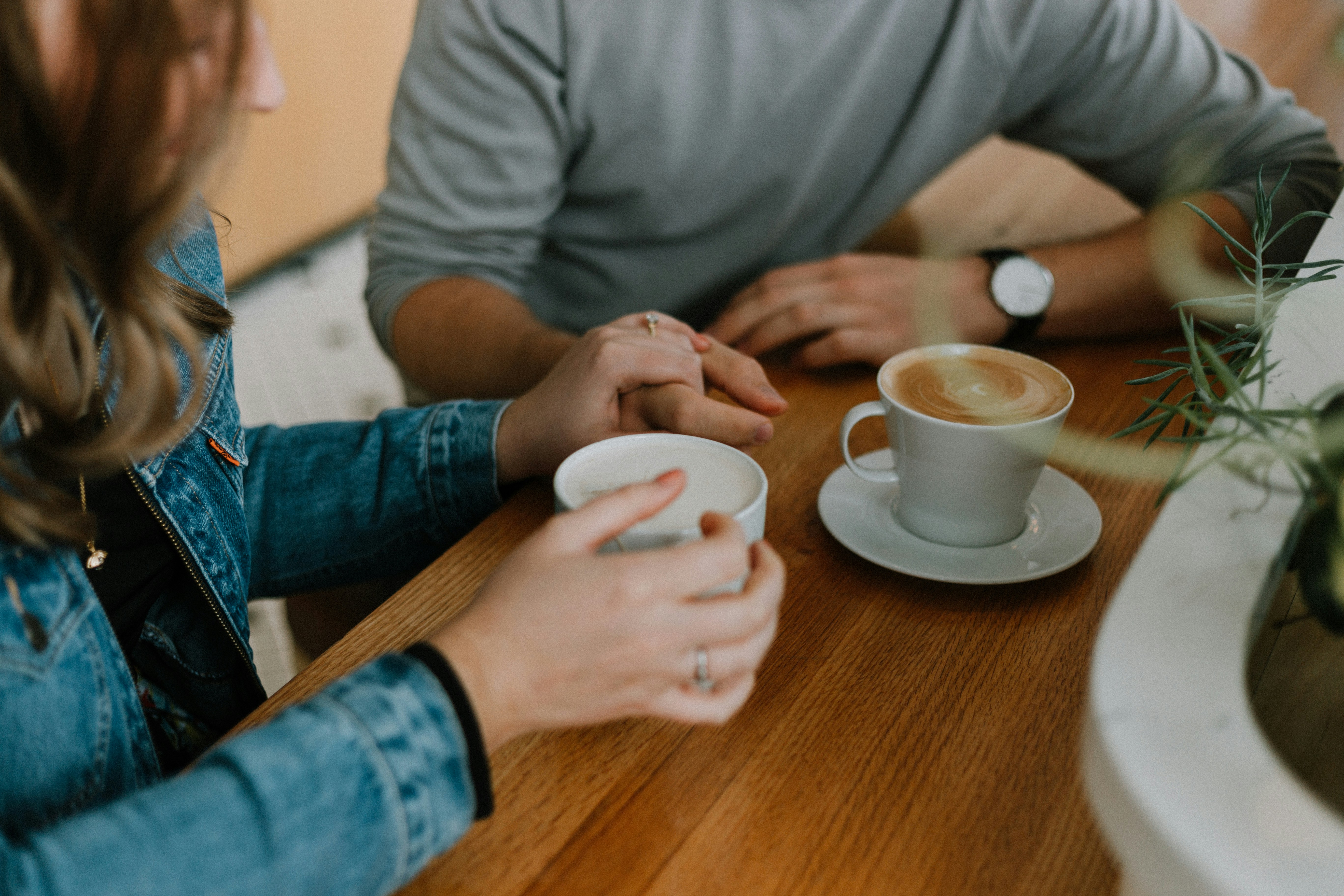 Two people holding hot drinks