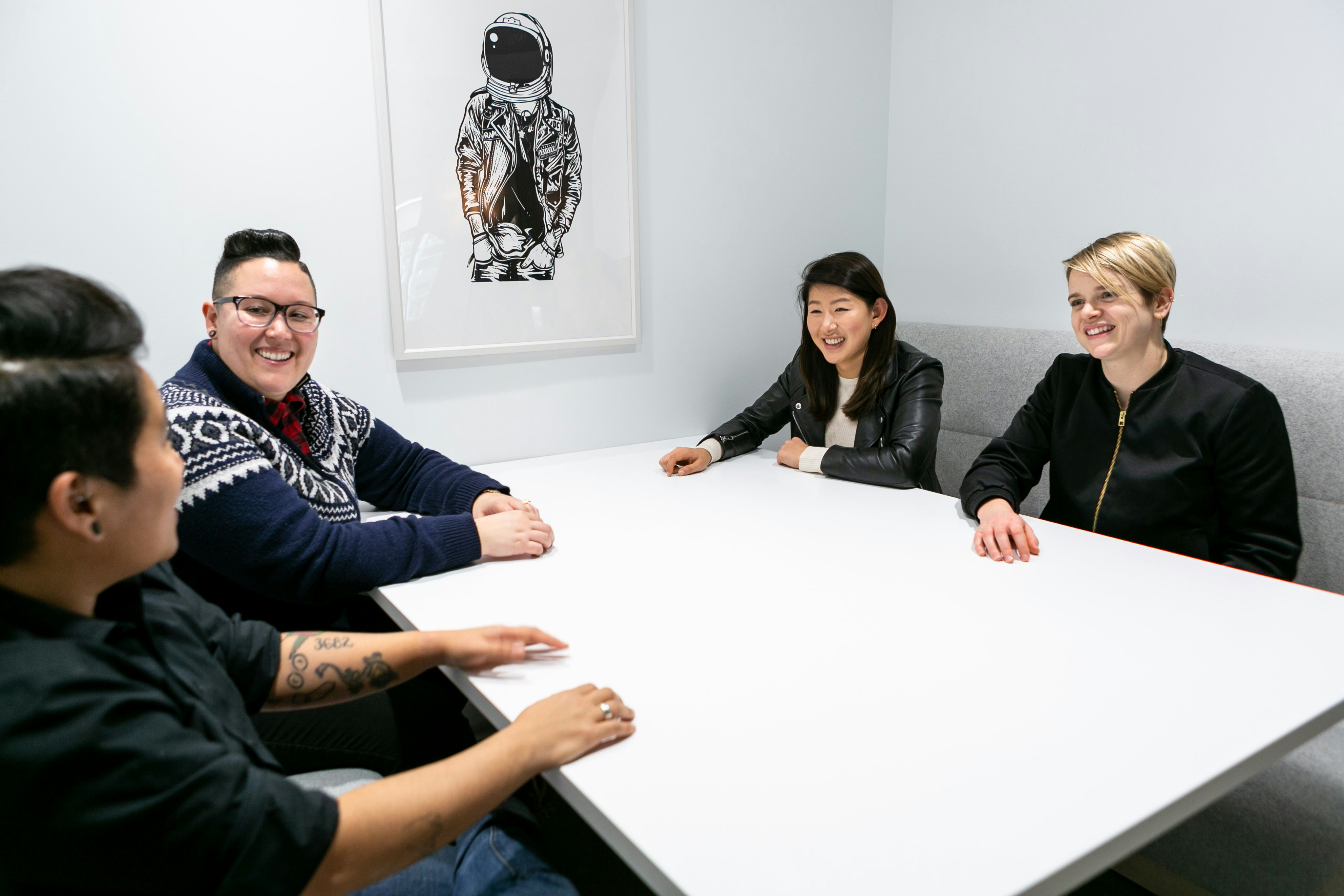 A group of three people sitting around a table talking