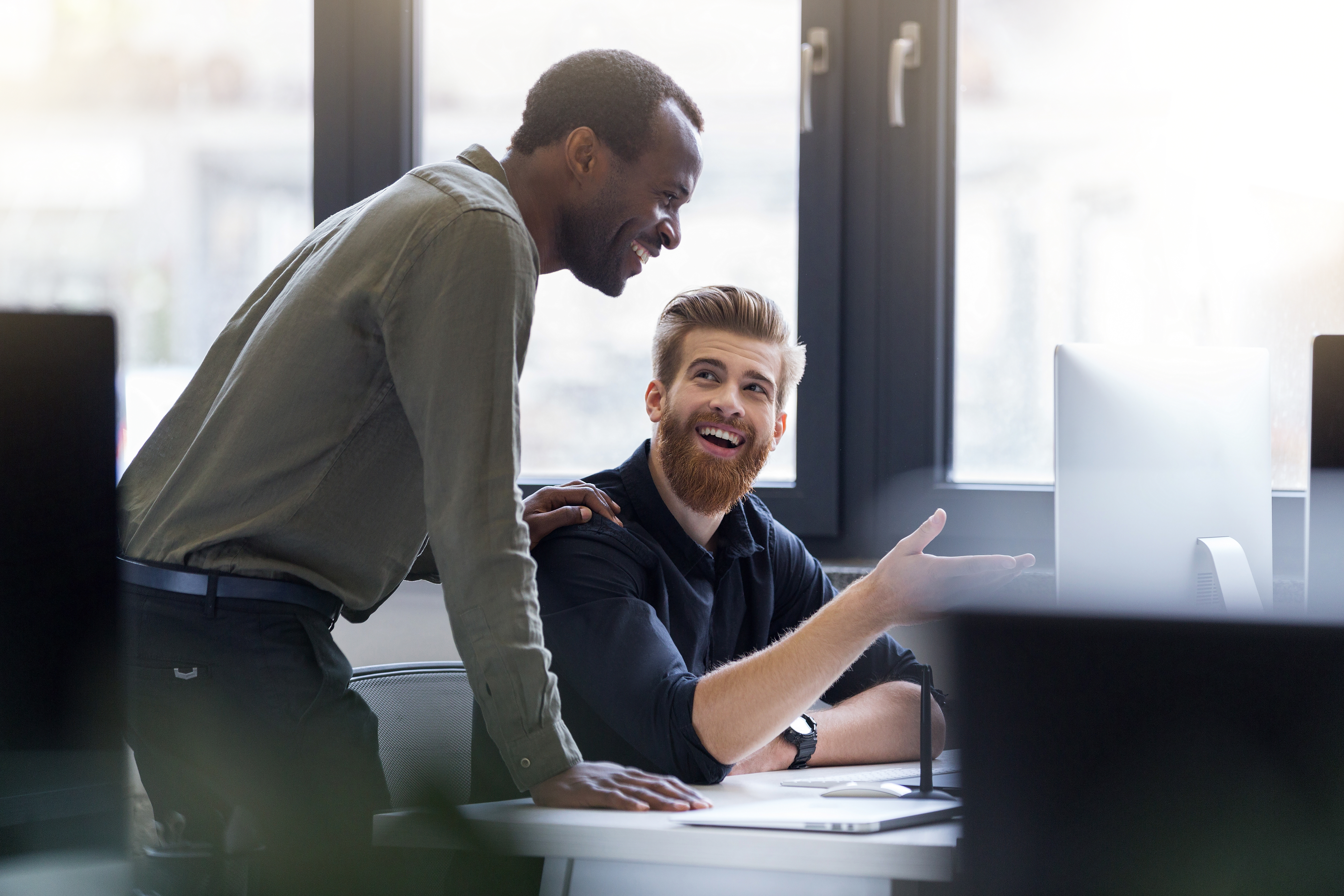 Two men talking at a desk