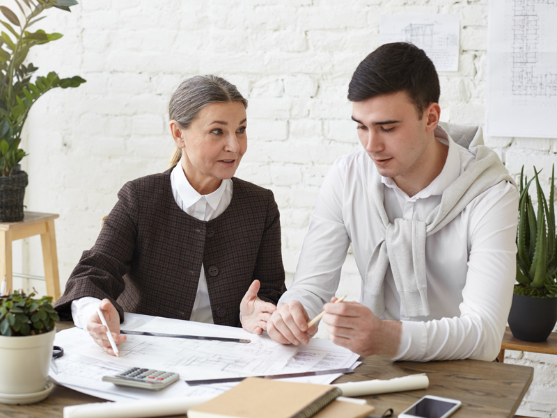 An woman teaching a young man