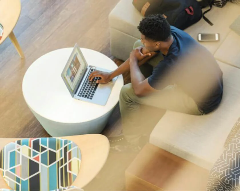 Ariel view of a Black man working on a laptop