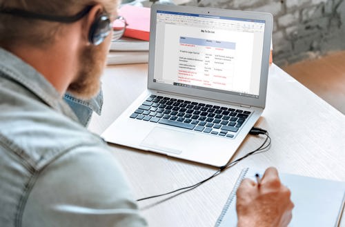 Man looking at laptop with todo list open