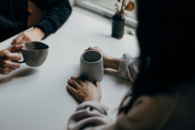 Two peoples hands holding cups