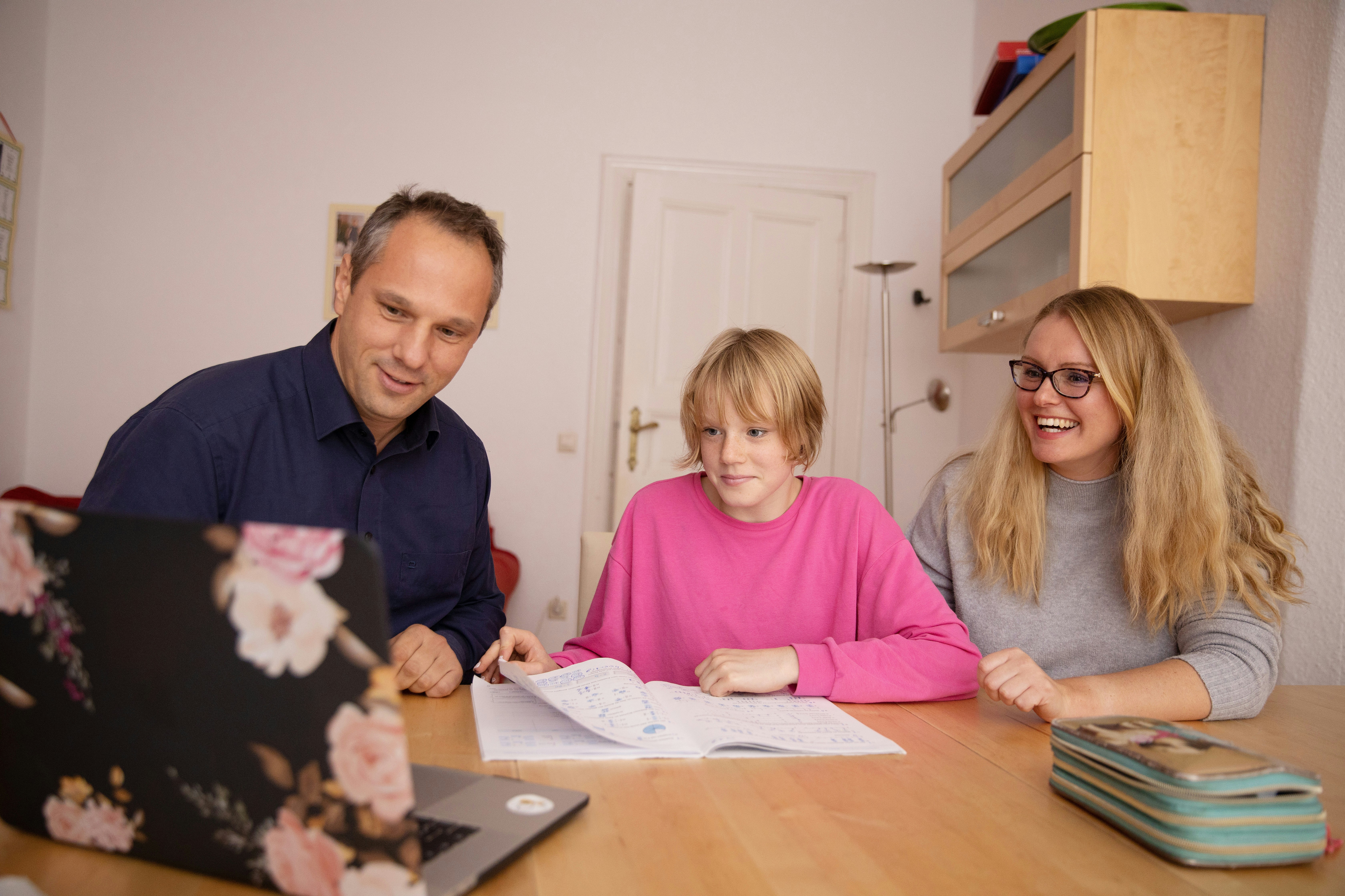 Parents helping daughter with homework